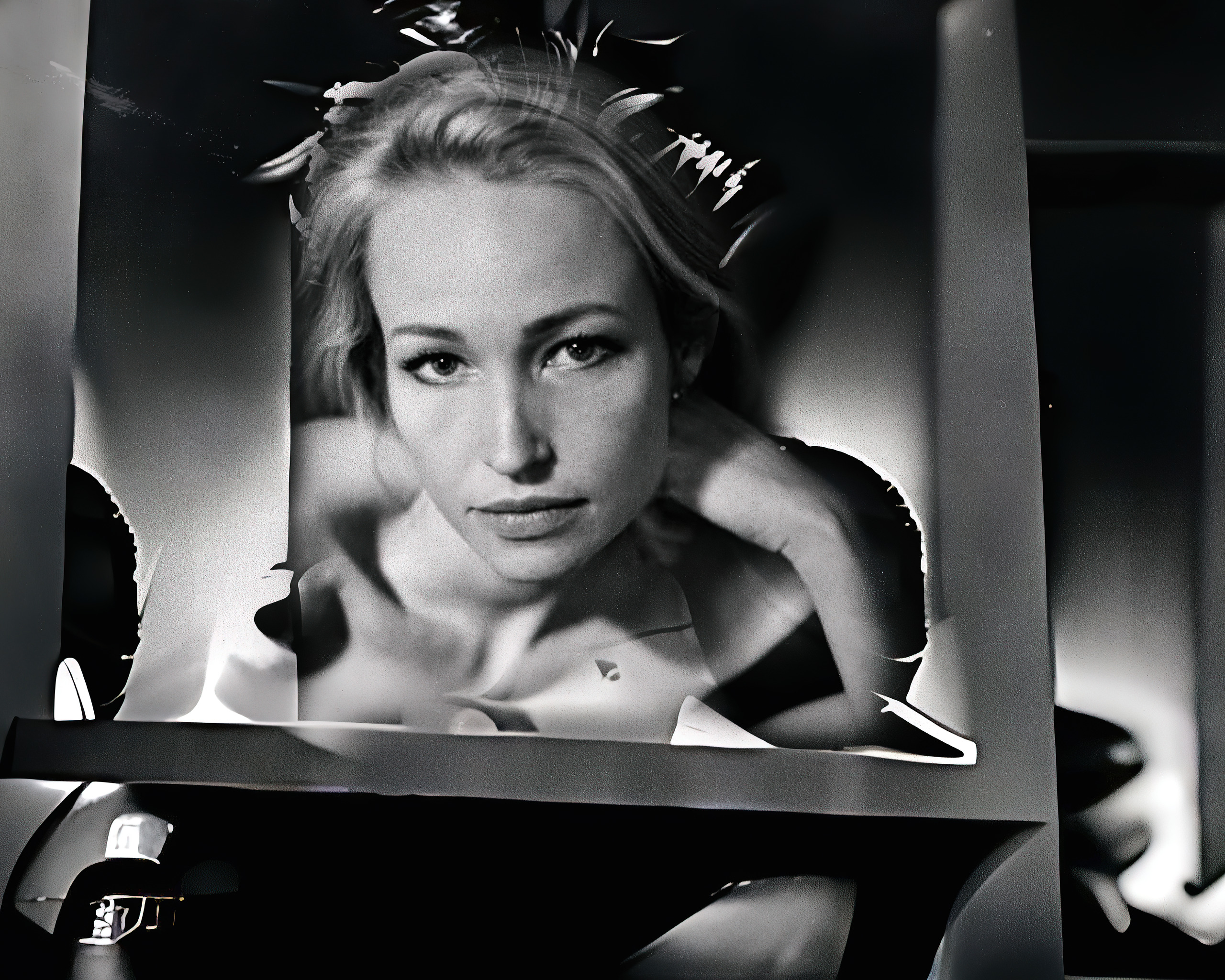Black and white fine-art photograph of a blonde woman framed inside a folded print, layered frames around her — by Hamudi Leon